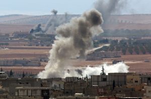 SANLIURFA, TURKEY - OCTOBER 9: A photograph taken from the border line in Suruc district of Sanliurfa, southeastern province of Turkey, shows destroyed buildings and rising smoke as a result of clashes between the Islamic State of Iraq and Levant (ISIL) and Kurdish armed groups in Kobane (Ayn al-Arab) city of Syria on October 9, 2014. (Photo by Emin Menguarslan/Anadolu Agency/Getty Images)